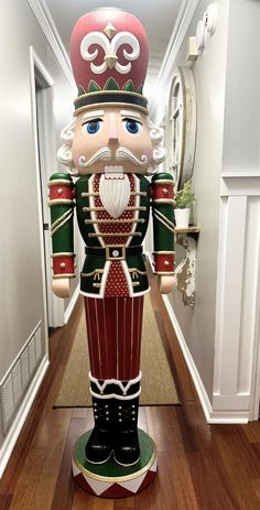 a large nutcracker standing in the middle of a hallway with wood flooring