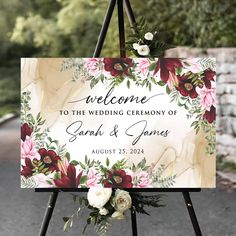 a welcome sign is decorated with flowers and greenery