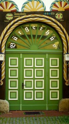 an entrance to a building with green doors