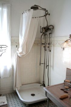 an old fashioned bathtub in the corner of a bathroom with white walls and tile flooring