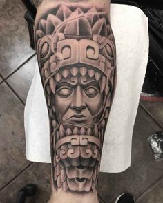 a man's leg with a tattoo on it and an image of a mask