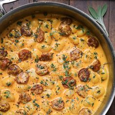 a pot filled with pasta and meatballs on top of a wooden table