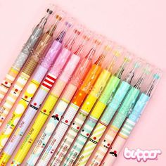 six different colored pencils are lined up on a pink background with the words happy written below them