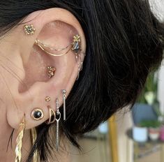 a close up of a person with ear piercings on their ears and behind the ear