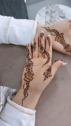 a woman's hands with henna tattoos on them