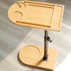 a wooden table with two trays attached to it and one on the floor below