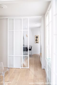 an empty room with white walls and wooden flooring is seen through the glass doors