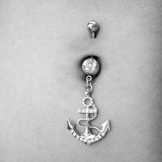 an anchor and diamond belly ring on a woman's stomach