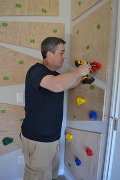 a man is working on the wall with some construction tools in his hand and he is holding a pair of pliers