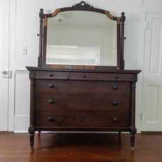 an old dresser with a mirror on top of it