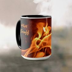 a black and white coffee mug with flames in the background that says hot fuff