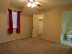 an empty room with a ceiling fan and toilet