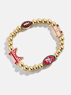 The San Francisco 49ers' NFL Charm Bracelet is the ultimate accessory for die-hard football fans. Each bracelet is a celebration of your favorite team, featuring the 49ers' logo along with other charms related to the team and its iconic location. Perfect for game days or everyday wear, this bracelet adds a touch of sports-inspired elegance to any outfit. This bracelet features 6mm gold ball beads. This is an officially licensed NFL product. 49ers Birthday, Football Jewelry, 49ers Logo, Disney Keychain, Beaded Charm Bracelet, Nameplate Necklace, Necklace Pendants, Crochet Bracelet, Bead Charm Bracelet