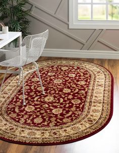 a red and beige area rug with an ornate design on the center in front of a window