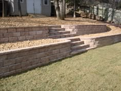 an outdoor retaining wall with steps leading up to the back door and side yard area