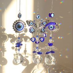 an evil eye mobile hanging from a chain with crystal beads and swarongs