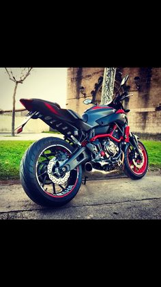 a red and black motorcycle parked on the street