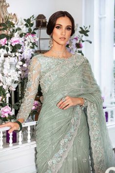 a woman in a green sari and matching jewelry