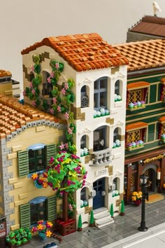 a lego model of a building with lots of windows and flowers on the side of it