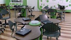 an empty classroom with laptops and desks