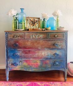 an old dresser with vases on top of it and other items sitting on top of it