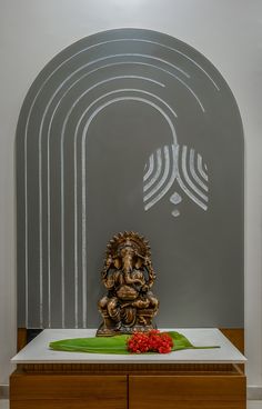 a statue sitting on top of a white table in front of a wall with arches