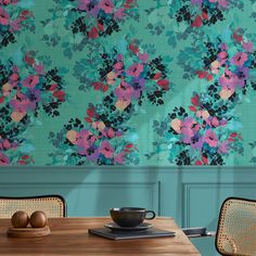 a teal floral wallpaper in a dining room with chairs and a wooden table