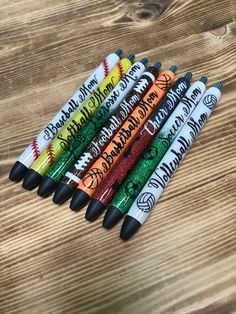 several different colored crayons sitting on top of a wooden table next to each other