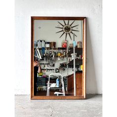 a person taking a photo in front of a mirror with a clock on the wall