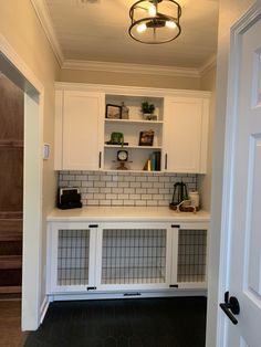 a kitchen with white cabinets and black tile flooring