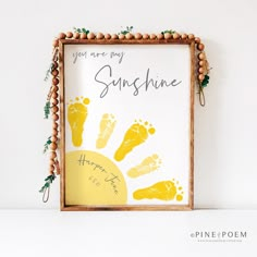 a wooden frame with a hand and foot print on it that says, you are my sunshine