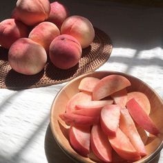 two bowls filled with sliced peaches on top of a table