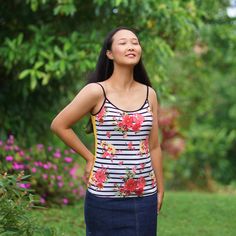 a woman standing in the grass with her hands on her hips looking up at something