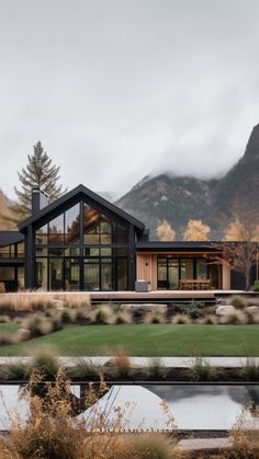 a large house sitting on top of a lush green field next to a mountain range