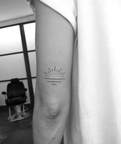 a person with a small sun tattoo on their arm