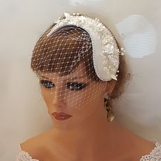 a mannequin wearing a veil and headpiece with flowers on it's side