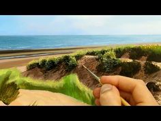 someone is painting the sand dunes at the beach