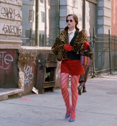 a woman walking down the street wearing red and pink tights