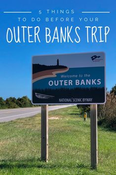 a sign that says outer banks trip in front of a road with trees and grass