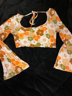 Crop top with big long bell sleeves,patterned with loud 60's flowers. The back has a string that ties running across the upper shoulder area.This shirt is also very mentionably soft. 60s Crop Top, 1970’s Bell Sleeve Shirt, 70s Shirts For Women, British Picnic, 19 Bday, Bell Sleeve Pattern, Orange Floral Top, Flower Power Fashion, 70s Tops