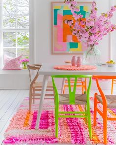 a room with white walls and colorful rugs on the floor next to a table