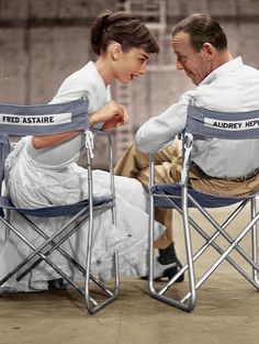 two people sitting in folding chairs facing each other