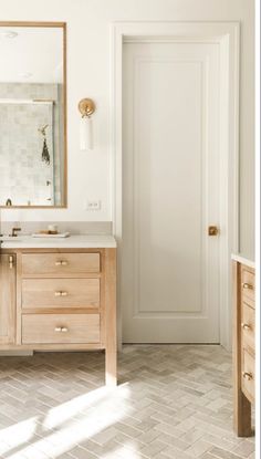 a bathroom with two sinks and a large mirror on the wall next to an open door