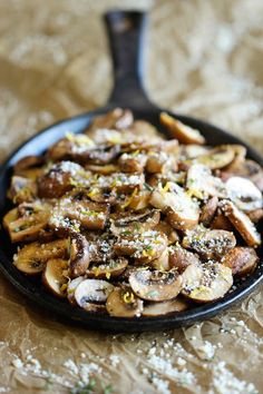 a skillet filled with mushrooms on top of a table