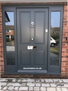 a grey front door with two sidelights