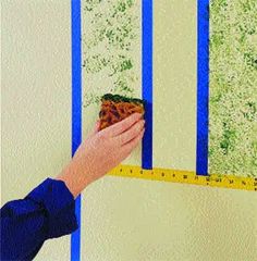 a person is measuring the wall with a tape and some green paint on it's walls