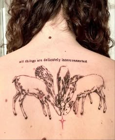 the back of a woman's upper body with three sheep on it and an inscription that says all things are politically interconnected