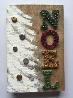 a christmas card with the word joy spelled out in beadwork and buttons on it