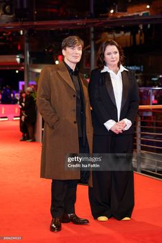 two people standing on a red carpet in front of an audience at the berlin film festival