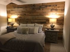 a bedroom with wood paneling on the wall and two nightstands next to it